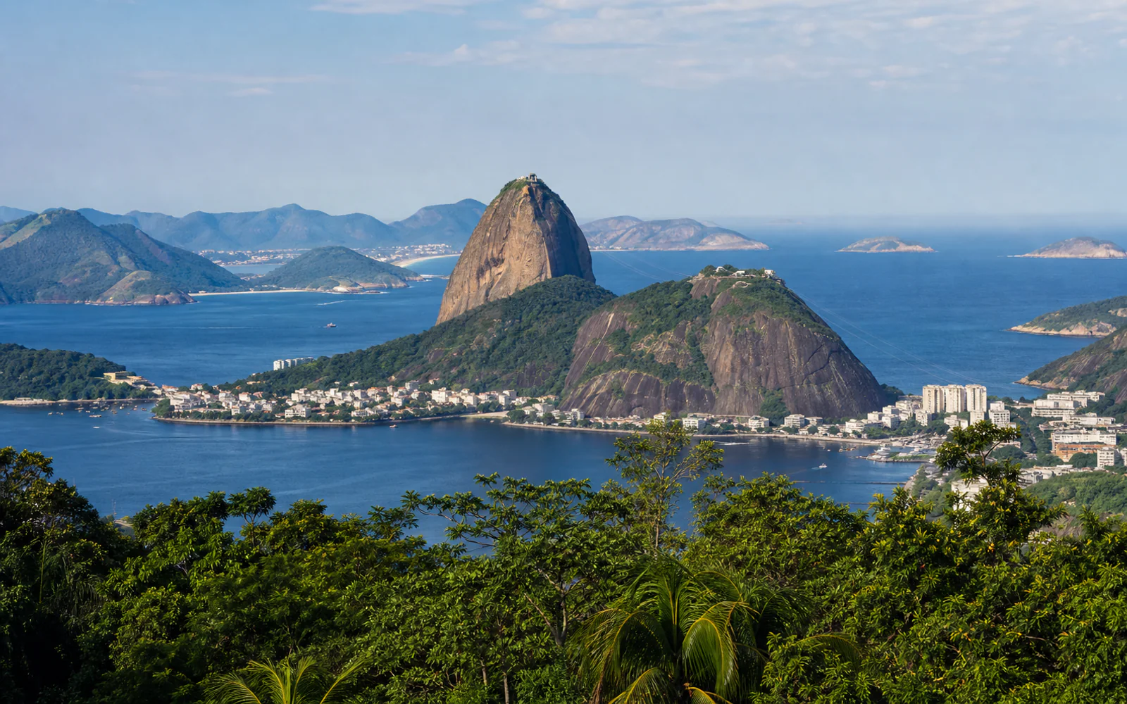 Sugarloaf Mountain and Guanabara Bay framed by tropical greenery in Rio de Janeiro