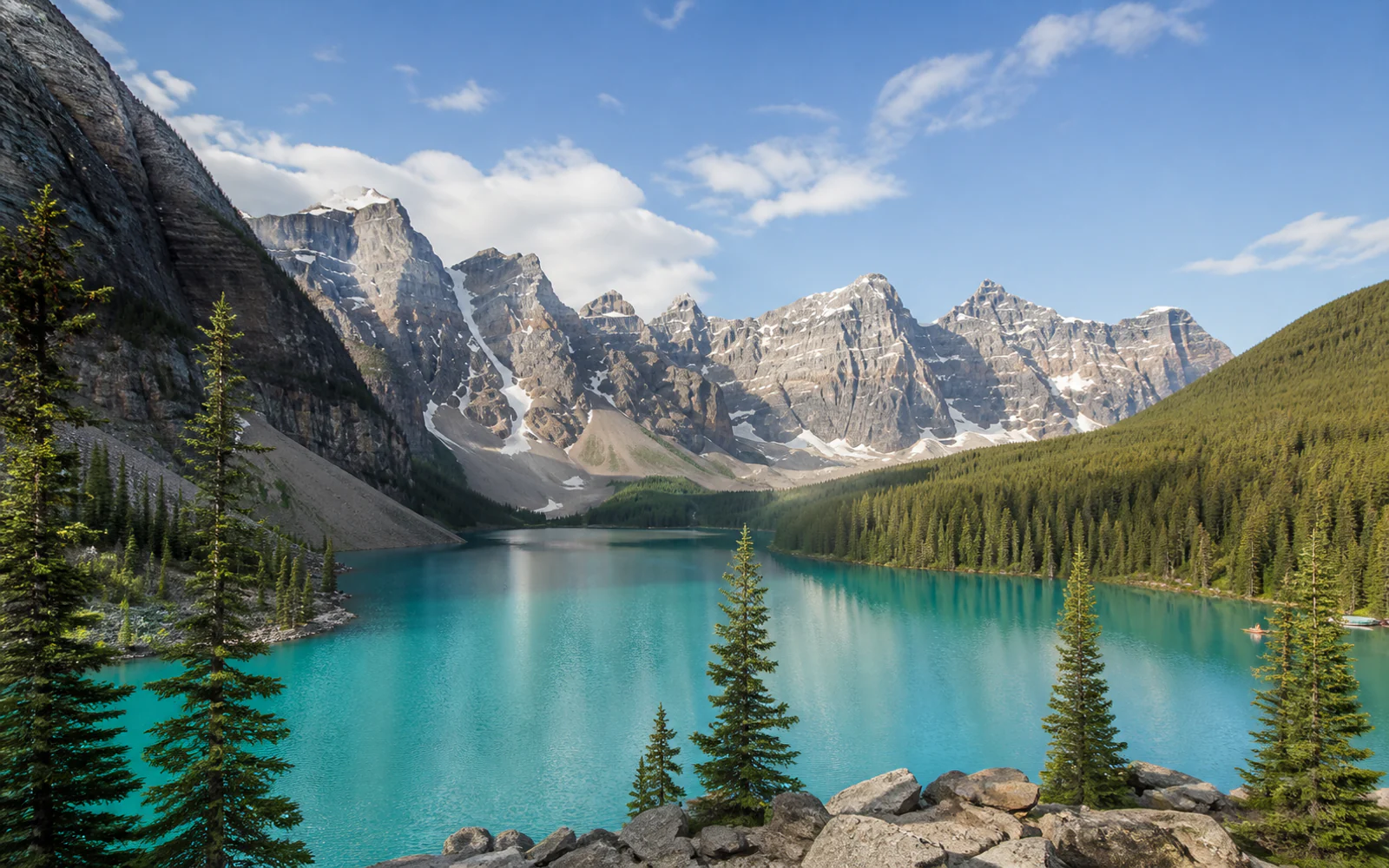 Turquoise alpine lake, evergreen forest, and peaks in the Canadian Rockies