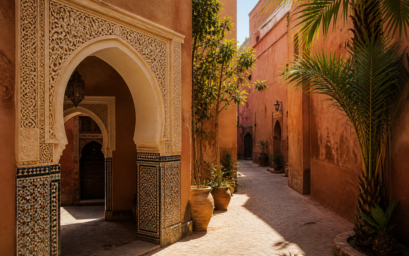 Traditional Marrakech arches, terracotta walls, and palm greenery in sunlight