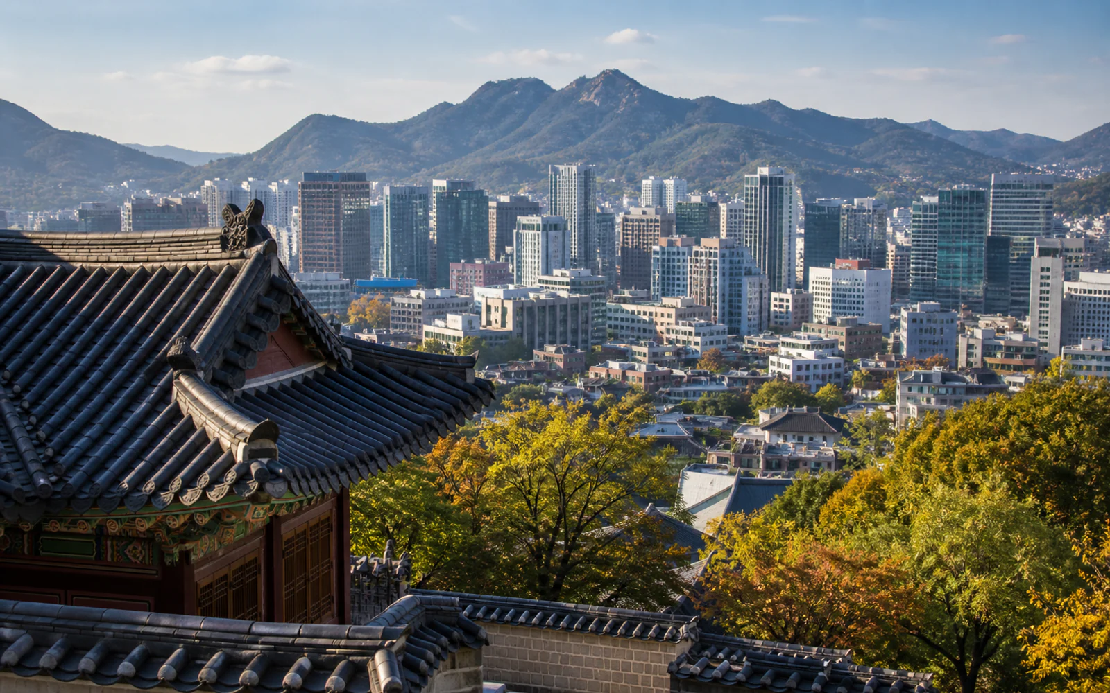 Traditional Korean rooflines overlooking Seoul's skyline and mountains